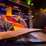 [Photo: Suzan Wilcox poses in a helicopter on the stage of the Rick Wilcox Magic Theater.]